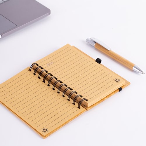 Caderno em capa de bambu com elástico, suporte para caneta e com 60 folhas pautadas.14 x 9 cm. Acompanha caneta de bambu com detalhes em plástico.