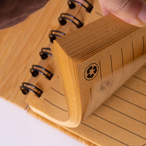 Caderno em capa de bambu com elástico, suporte para caneta e com 60 folhas pautadas.14 x 9 cm. Acompanha caneta de bambu com detalhes em plástico.