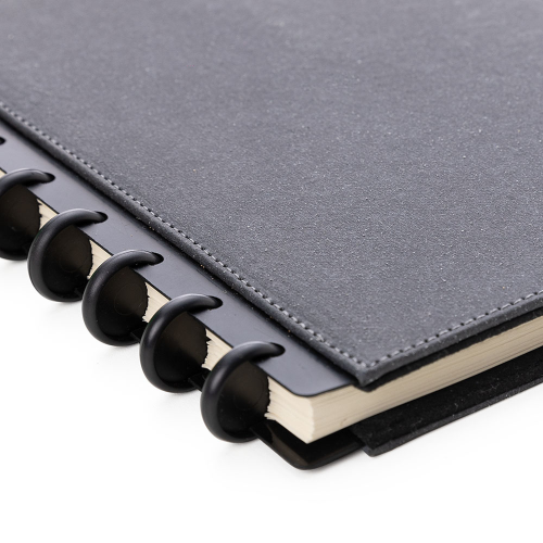 Caderno capadura em material sintético, com porta cartões e porta canetas. 80 folhas.